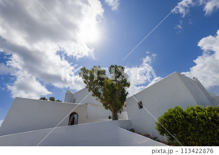 Stark architecture of Puig de Missa church, lone tree against a sky of azure in Ibiza 113422876