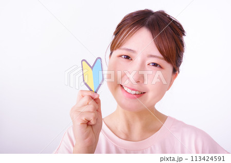 初心者マークをもったスポーツウェアの女性 初心者マークをもったスポーツウェアの女性 113424591