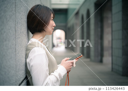 東京丸の内のお店をスマホで探す女性 113426443