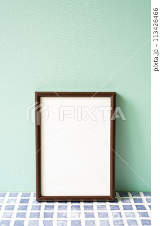 Wooden picture frame on blue tile shelf. mint wall background. copy space Wooden picture frame on blue tile shelf. mint wall background. copy space 113426466