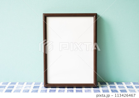 Wooden picture frame on blue tile shelf. mint wall background. copy space 113426467