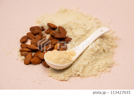 Almond flour and almonds on a beige background Almond flour and almonds on a beige background 113427035