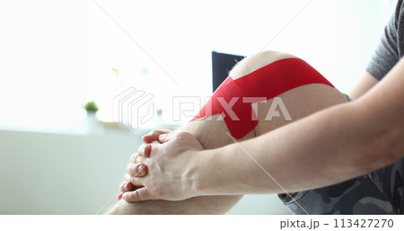 Therapeutic treatment of leg with red physio tape Therapeutic treatment of leg with red physio tape 113427270