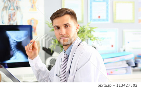 Doctor examines x-ray of cervical spine closeup 113427302
