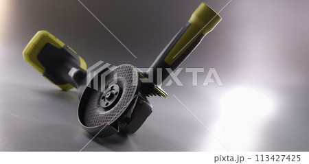 Professional angle grinder with disc on gray background Professional angle grinder with disc on gray background 113427425