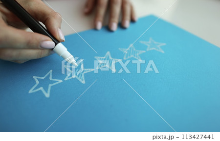 Person draws five stars in the recommendations with white felt-tip pen reviews Person draws five stars in the recommendations with white felt-tip pen reviews 113427441