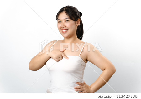 Asian woman checking lumps on her breast for signs of breast cancer on white background. 113427539