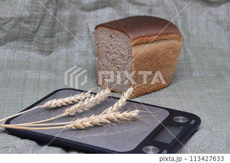 Dry ears on the scales nearby are banknotes, the global food crisis, grain exports, crop growth. Dry ears on the scales nearby are banknotes, the global food crisis, grain exports, crop growth. 113427633