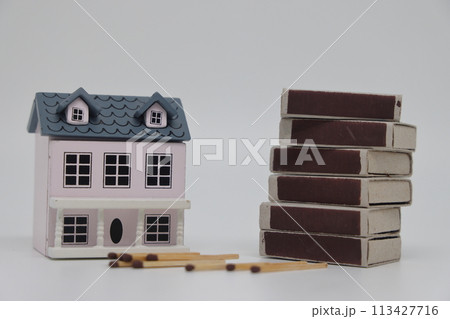 Matches and matchboxes next to a toy house on a light background. Real estate insurance concept. 113427716