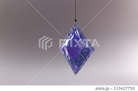 Condom package on a gray background. Safe sex and health 113427750