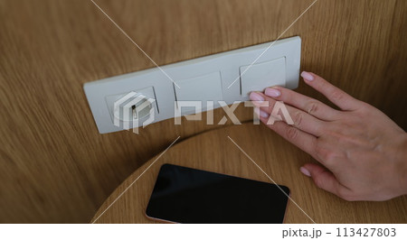 Woman hand presses on turn off lights closeup Woman hand presses on turn off lights closeup 113427803