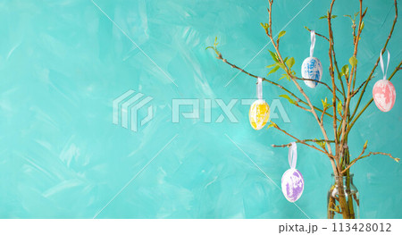 Holiday card template. Easter tree on turquoise background. Color eggs hanging on spring twigs. Holiday card template. Easter tree on turquoise background. Color eggs hanging on spring twigs. 113428012