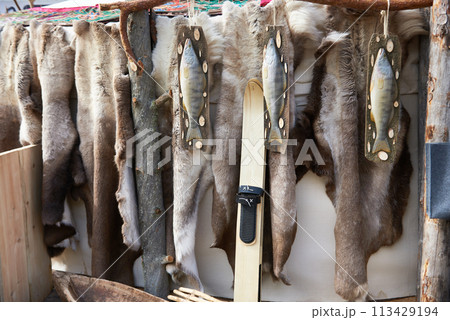 Hunter skis, fish and reindeer skins 113429194