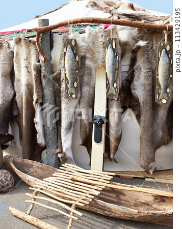 Hunter skis, wooden boat and reindeer skins 113429195