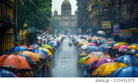 Mumbai. Rainy streets of Mumbai with vivid umbrellas and iconic terminus in the backdrop 113431373