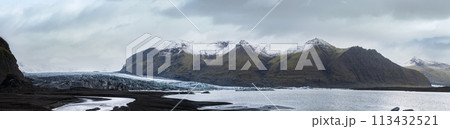 Skaftafellsjokull glacier, Iceland. Glacier tongue slides from the Vatnajokull icecap or Vatna Glacier near subglacial Esjufjoll volcano. Glacial lagoon with ice blocks and surrounding mountains. 113432521