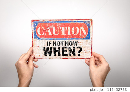 If Not Now When. Metal warning sign in a woman's hand on a white background If Not Now When. Metal warning sign in a woman's hand on a white background 113432788
