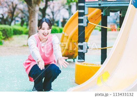 公園の遊具の前で子供と遊ぶ保育士 113433132