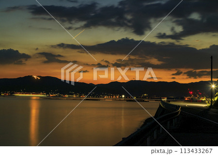 夕焼けの瀬戸内の万葉火と海岸道路 113433267