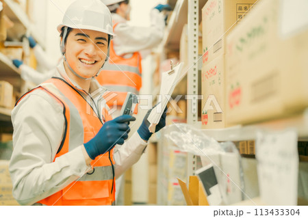 端末で入出庫管理する男性管理者 113433304