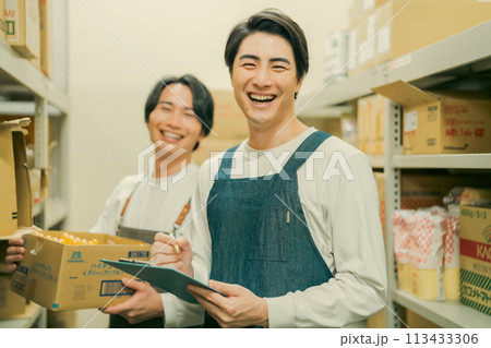 倉庫での軽作業をするエプロン姿の作業員 113433306