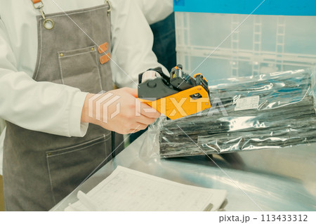 バックヤードで軽作業をする若い男性　顔無し 113433312