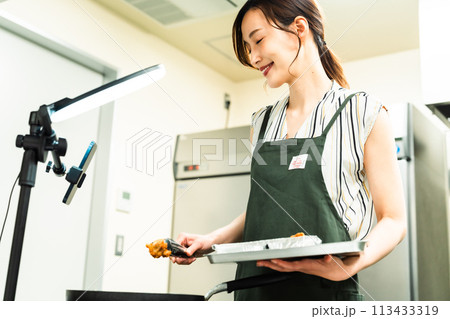 動画配信で料理を作るインフルエンサーの女性 113433319