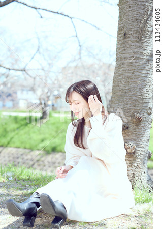 桜の下で座る女性 113434605