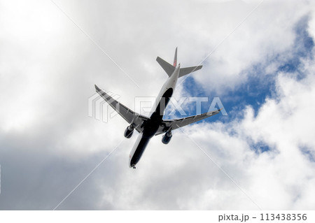 White passenger airplane flying in the sky amazing clouds in the background 113438356