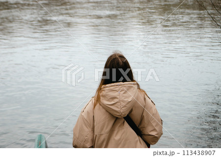 A woman with long brown hair near river in spring 113438907