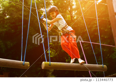 adventure climbing high wire park - people on course in mountain helmet 113440773