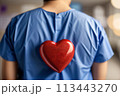 Heart surgeon seen from behind in blue coat goes for open-heart surgery in hospital ward 113443270