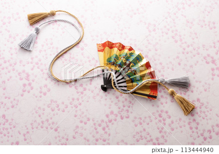 扇と組紐とピンク色の和紙の和風イメージ　 113444940