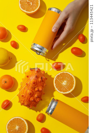 Tropical fruit and tin cans in hand on yellow background, top view 113445421