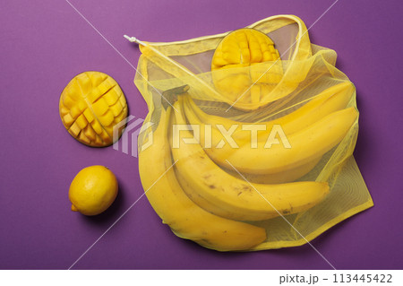 Tropical fruit in bag on purple background, top view 113445422