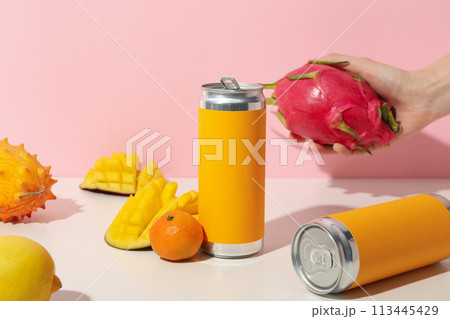 Tropical fruit, tin cans and hand on light pink background 113445429