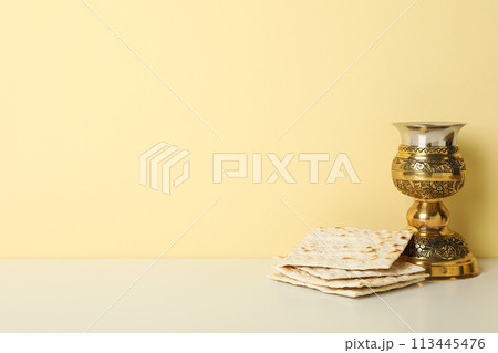 Matzo and cup on light yellow background, space for text Matzo and cup on light yellow background, space for text 113445476