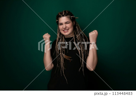 Woman With Dreadlocks Standing in Front of Green Wall 113448483