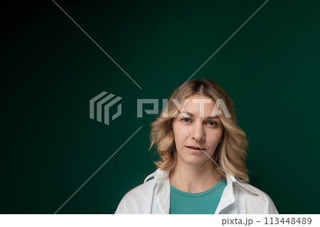 Woman Standing in Front of Green Background 113448489