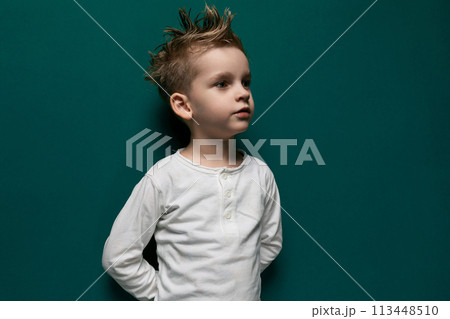 Little Boy Standing in Front of Green Wall Little Boy Standing in Front of Green Wall 113448510