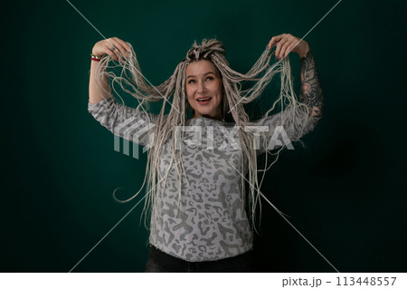 Woman With Dreadlocks Standing in Front of Green Background Woman With Dreadlocks Standing in Front of Green Background 113448557