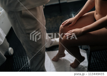 High-angle view of unrecognizable masseur male make relaxing therapeutic head massage to young woman in wellness center. Happy pretty female getting head massage by professional masseur in spa salon. 113449435