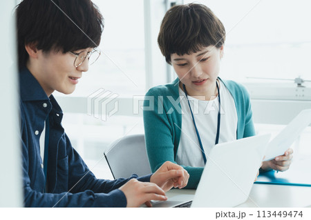 パソコンで仕事をする若い男女 113449474