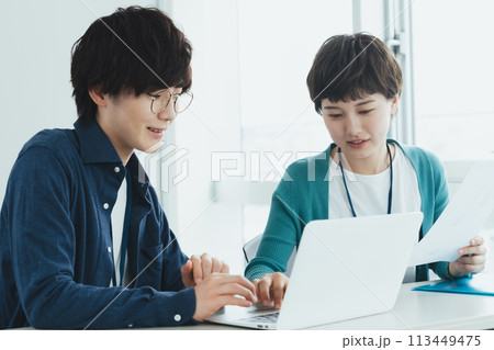 パソコンで仕事をする若い男女 パソコンで仕事をする若い男女 113449475