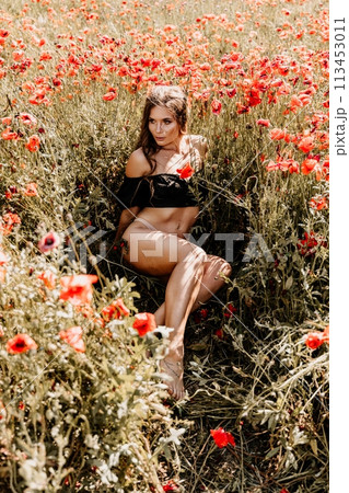 Woman poppies field. portrait happy woman with long hair in a poppy field and enjoying the beauty of nature in a warm summer day. 113453011