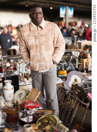 Ordinary afro-american seller in a flea market is waiting for buyers 113455755