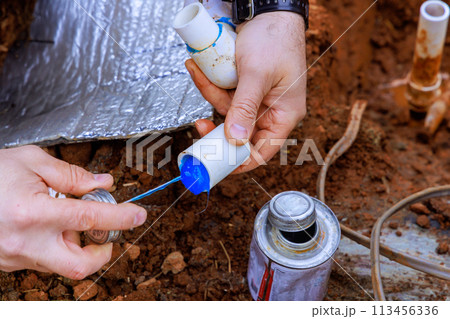 Before gluing plastic pipe with glue, plumber seals that pipe with glue 113456336