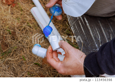 Before gluing a pex pipe, plumber seals it with glue Before gluing a pex pipe, plumber seals it with glue 113456398