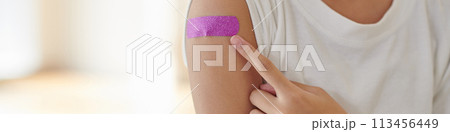 Header with teenage girl pointing at pink bandage on arm 113456449