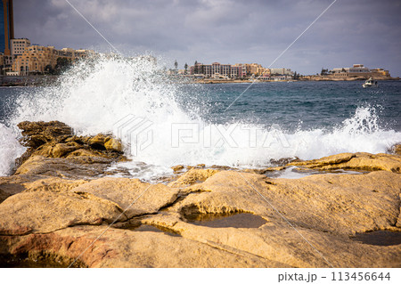 High waves of the ocean on a rocky shore. Coast of the island of Malta in winter 113456644
